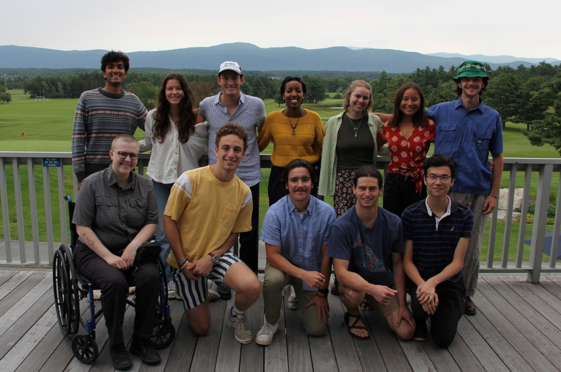 The 12 students in the SSL Summer 2023 cohort smiling in front of the green mountains