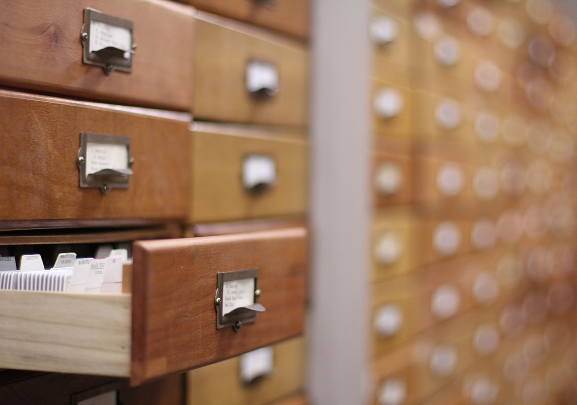 A card catalog with one drawer open.