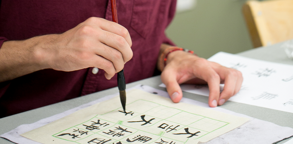 Close up of hands painting Chinese characters