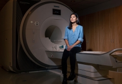 Elle Murata ’17 Sitting on the bed of an MRI machine