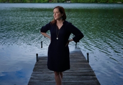 Rebecca Makkai MA ’04 standing on the dock of a lake with her hands on her hips