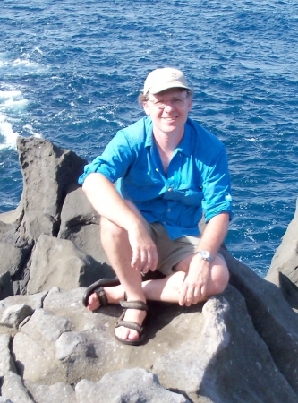 Mike Sheridan sitting on a rock by the ocean