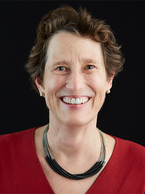 Ann Jones-Weinstock in red top with black-and-gold necklace