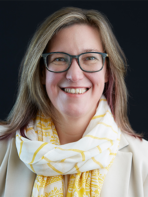Elizabeth Lindau in cream jacket and yellow-patterned scarf