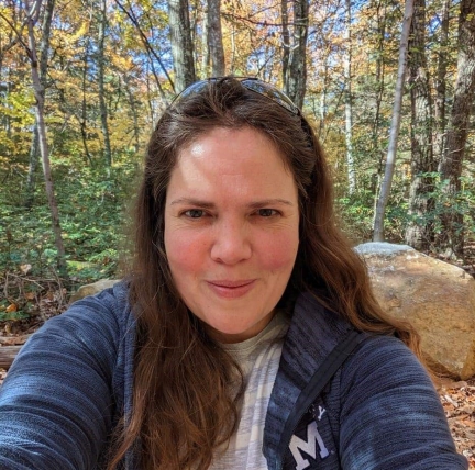 Smiling woman in front of fall foliage