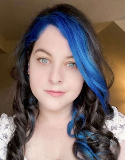 Woman with long blue and brunette hair looking into camera