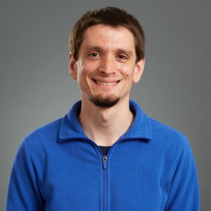 Man with short brown hair and light blue polo shirt