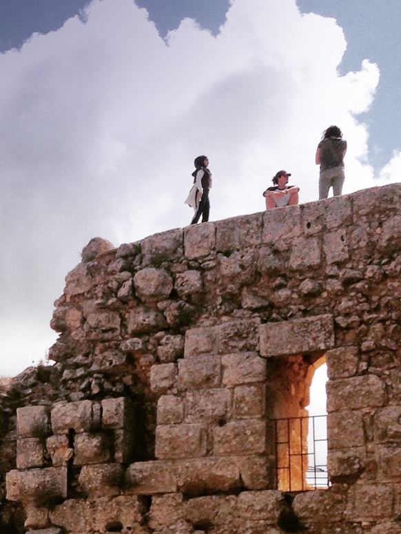 People stand on top of a old stone structure.