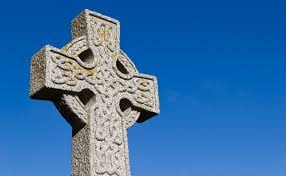 stone Celtic cross against a blue sky