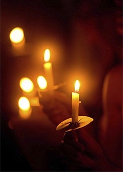 soft-focus hand-held candles against a dark background