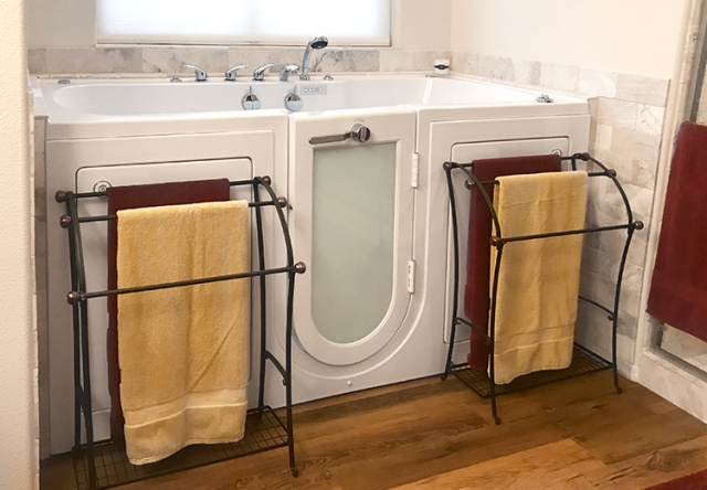 Walk-in bathtub with towel racks in front of it