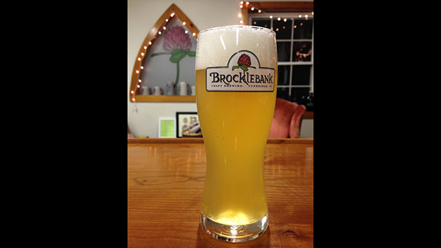 a foamy pale yellow beer in a tall glass labeled "Brocklebank"