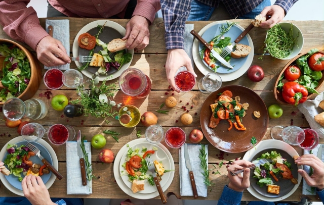 various dishes and hands around a wooden table