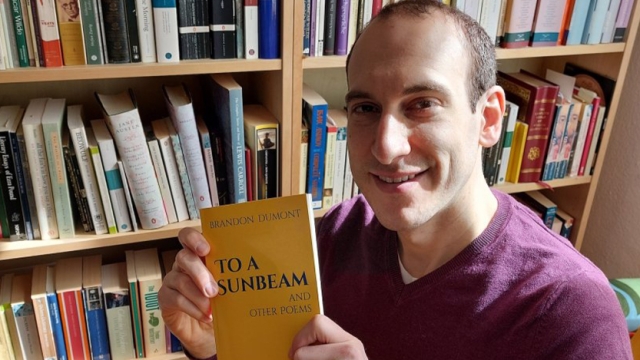 Brandon Dumont holding his poetry book, To a Sunbeam