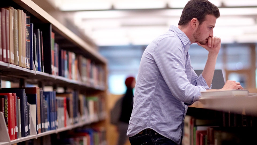A student in the stacks at Davis Library.