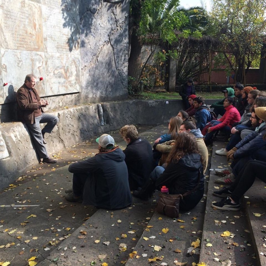 students seated on stone steps participating in discussion