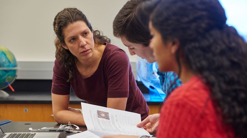 A professor works with students on a human research project.