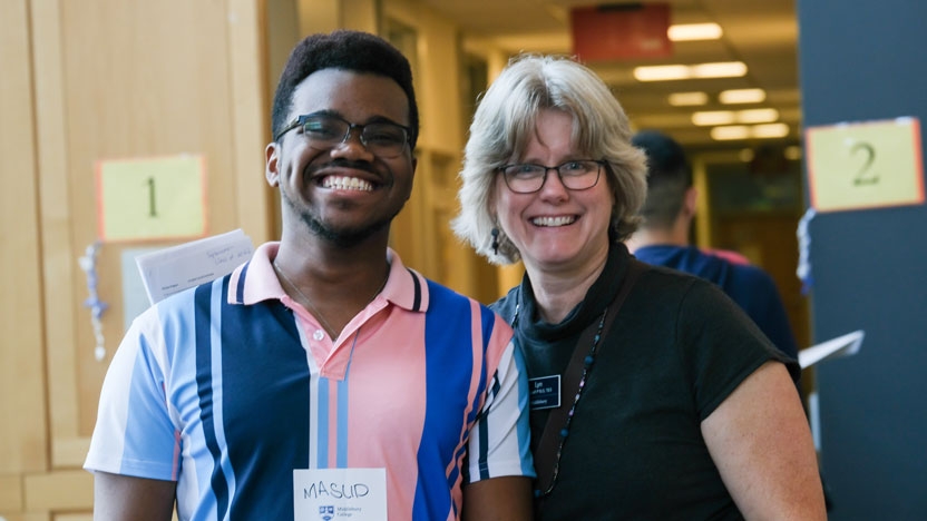 An international student and his local host pose together.