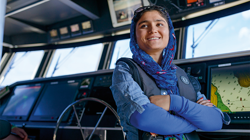 a confident student wearing a headscarf aboard a research vessel on Lake Champlain