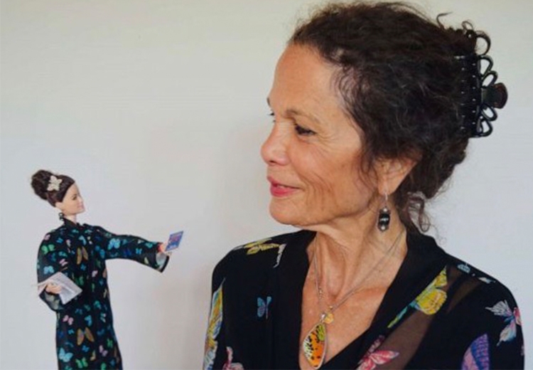 Writer and Middlebury Alumna Julia Alvarez examines a Barbie Doll that has been designed in her likeness