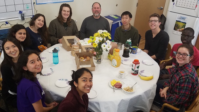 Students sitting around dinner table at the interfaith house
