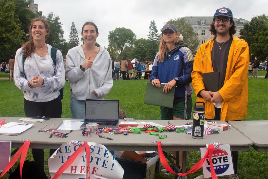 MiddVotes student leaders smile as they greet first year students at Middlebury's Student Activities Fair.