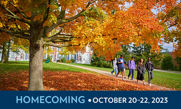 a group of five young people walk past the Chateau surrounded by bright orange foliage on trees and the lawn