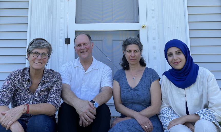four smiling people seated