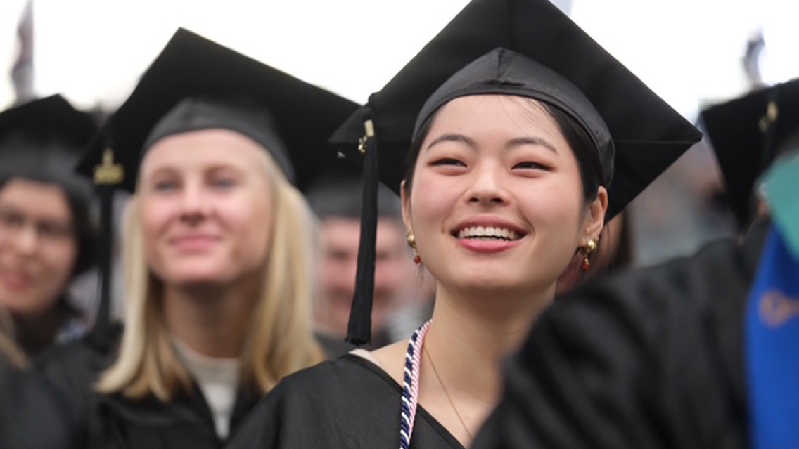 Students in caps and gowns smiling