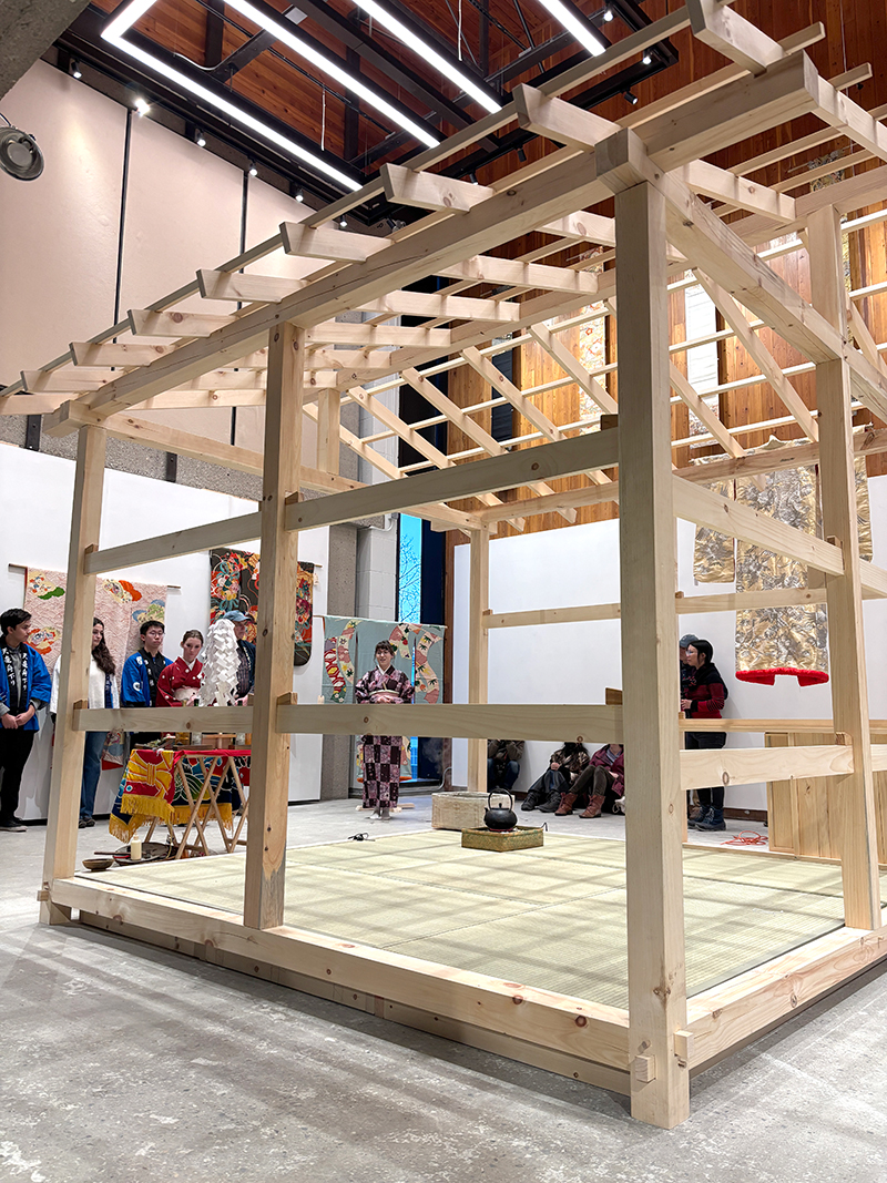 Students stand outside a newly constructed Japanese teahouse.