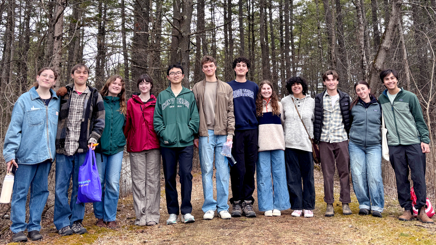 Group of students poses for a photo in the woods.