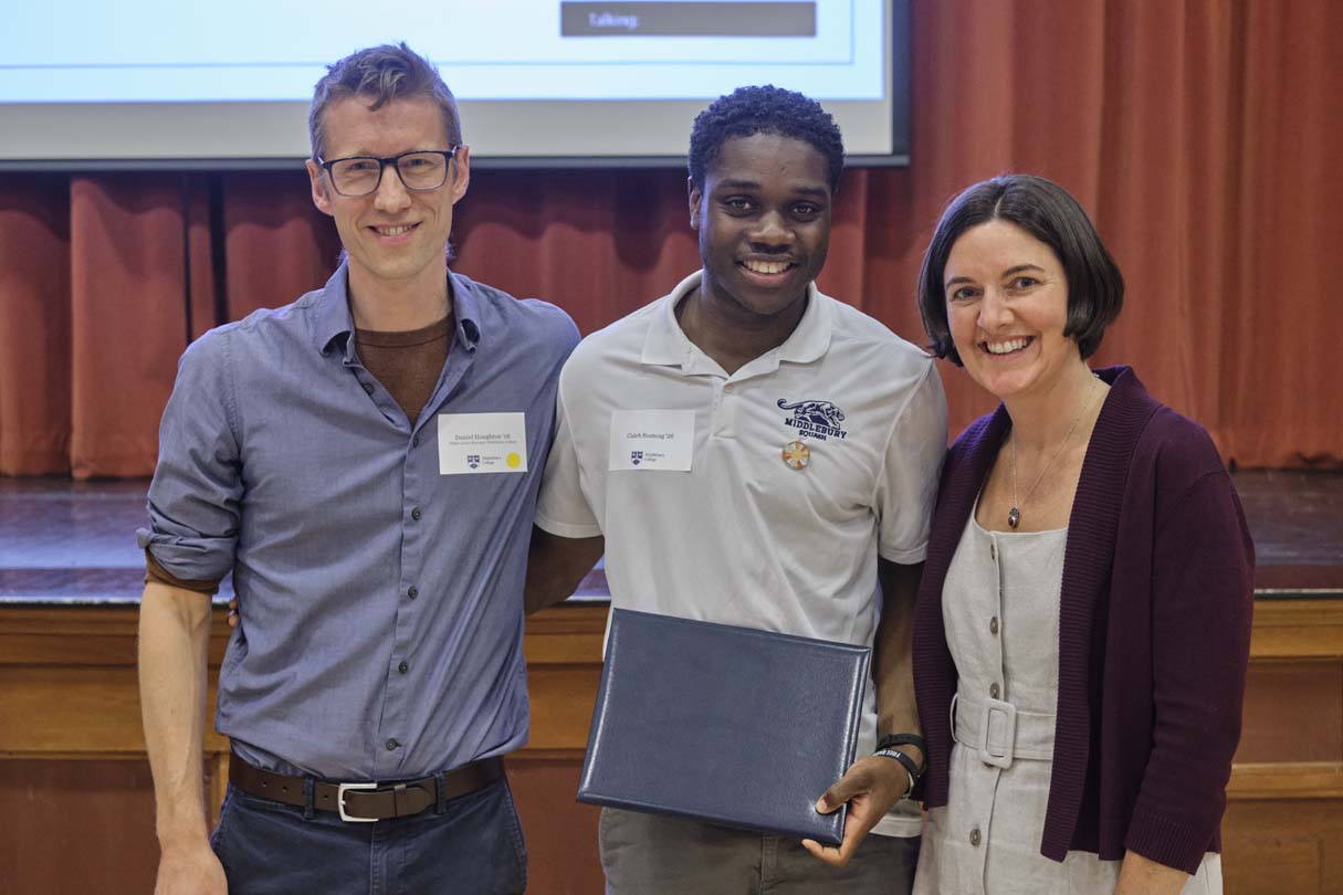 Three people pose for a photo during an awards ceremony.
