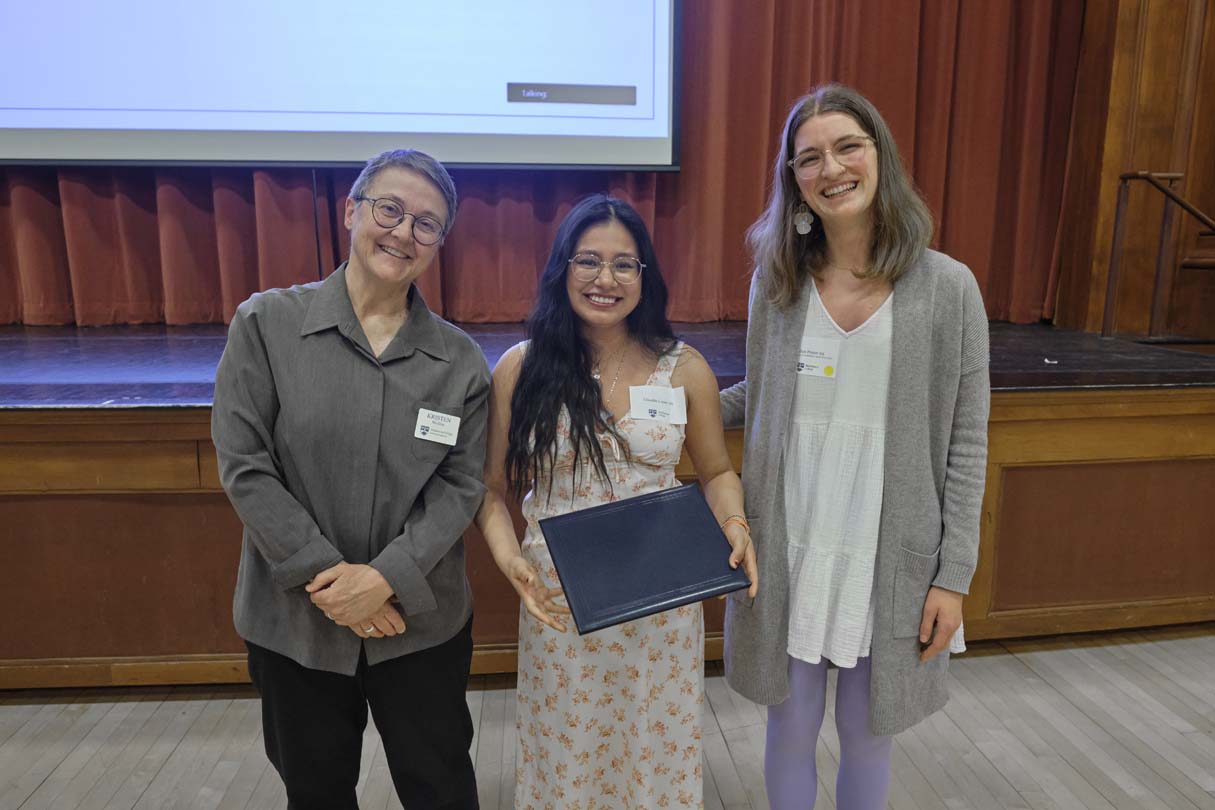 Three people pose for a photo during an awards ceremony.