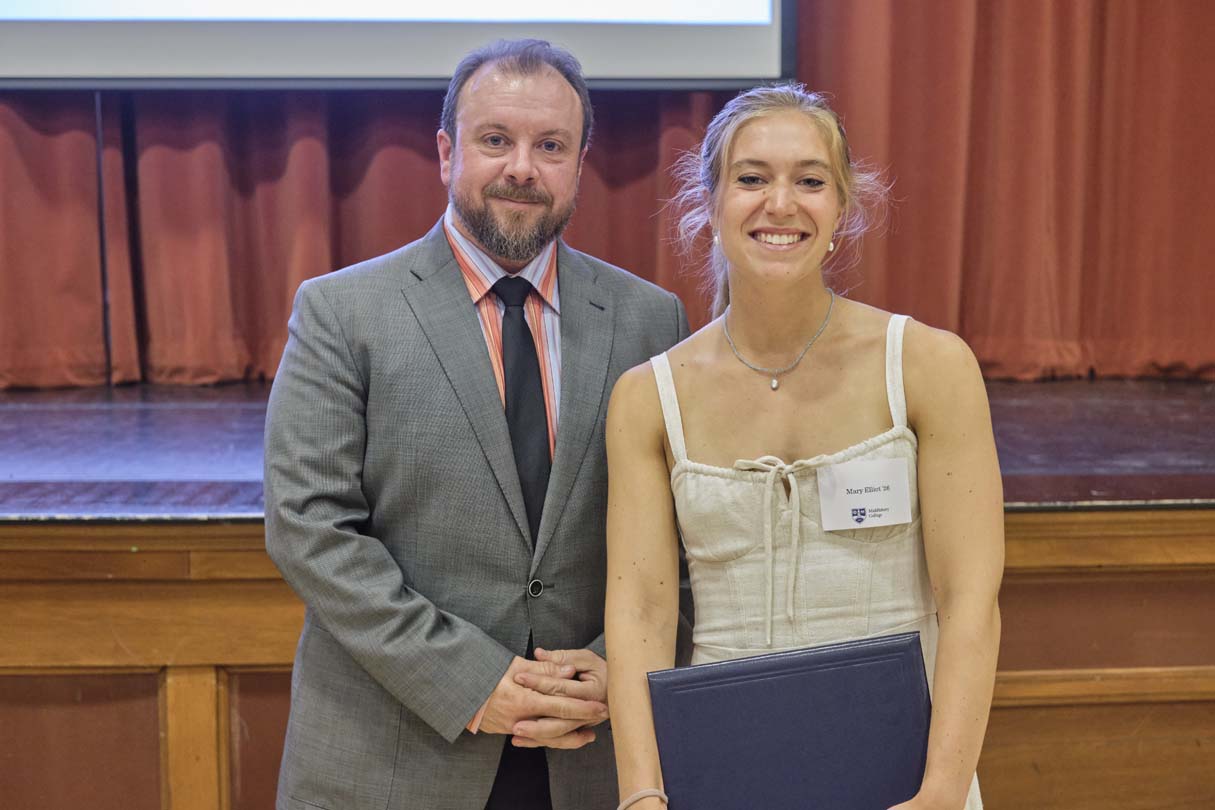 Two people pose for a photo during an awards ceremony.