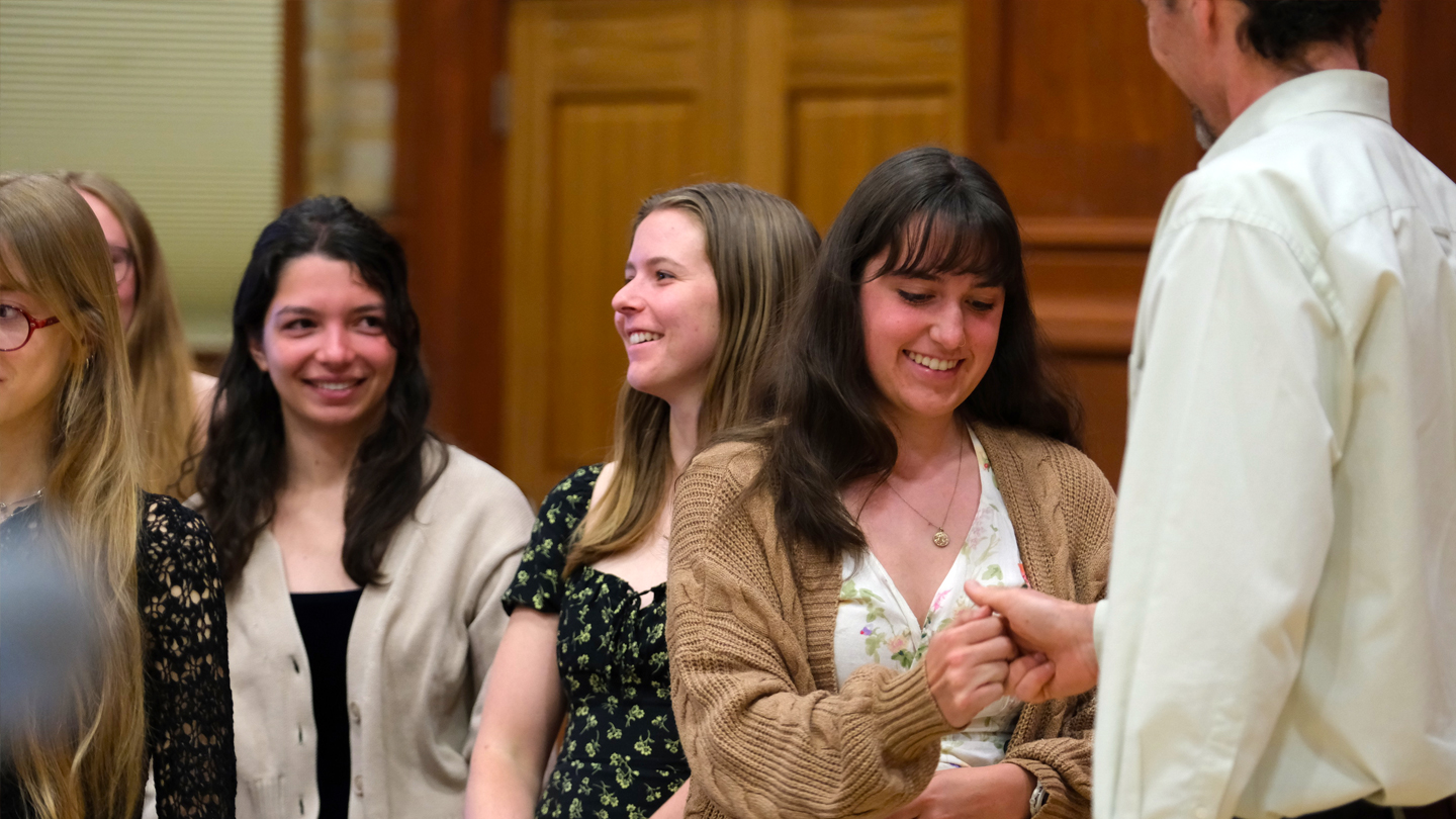 A student learns the Phi Beta Kappa handshake.
