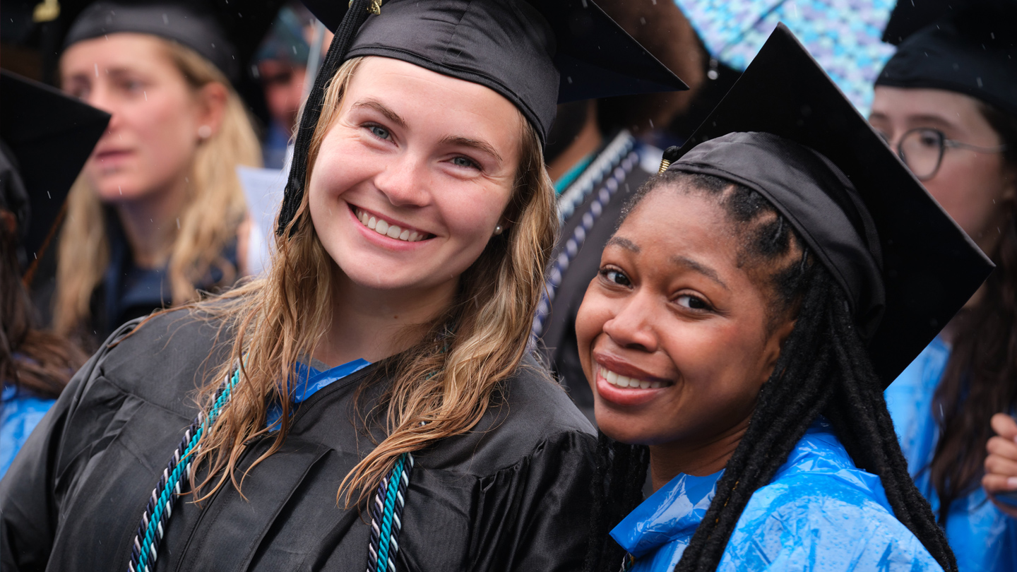 Two students smile as they wait for Commencement to begin.