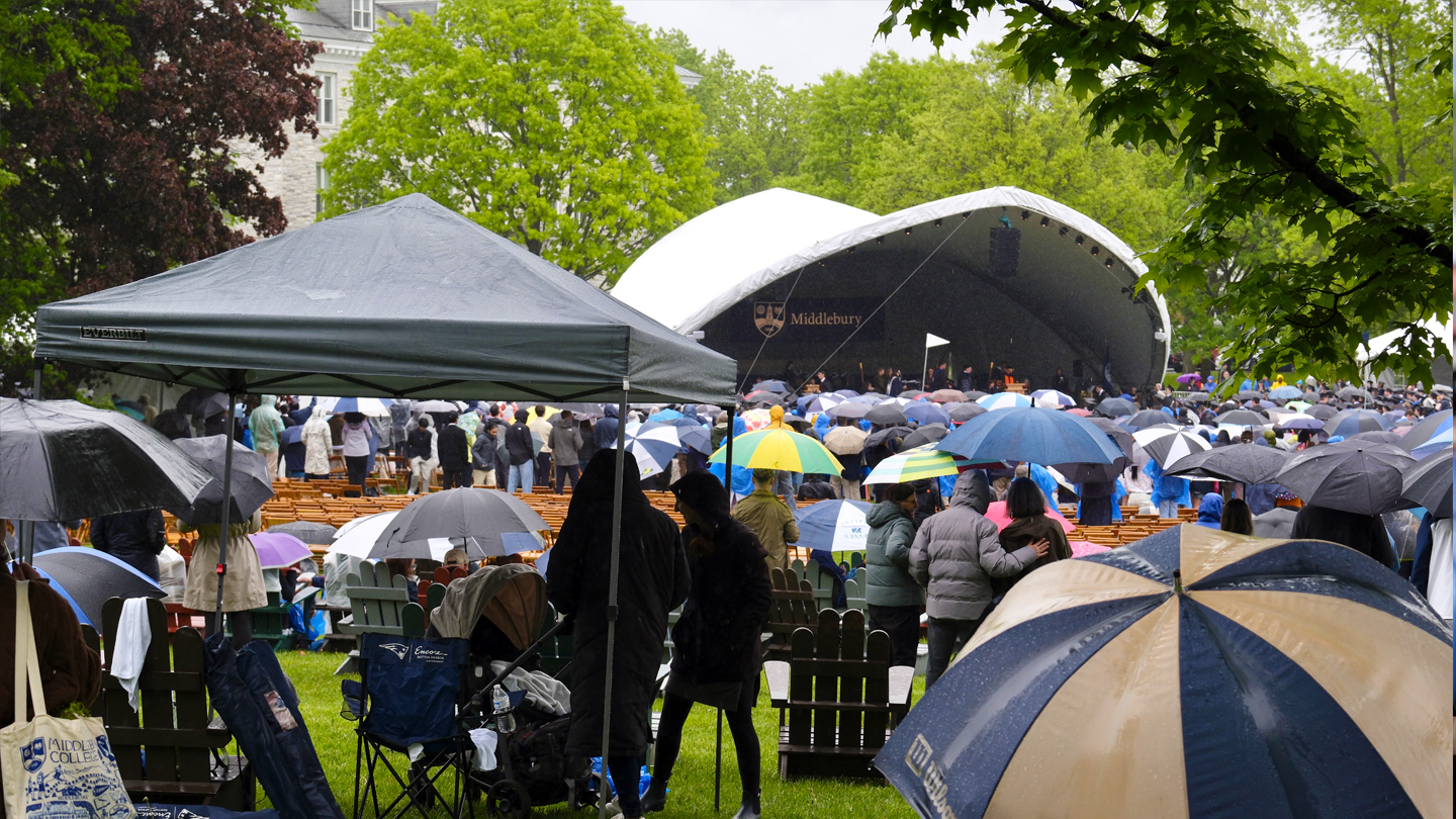 Photo of rainy commencement grounds with umbrellas.
