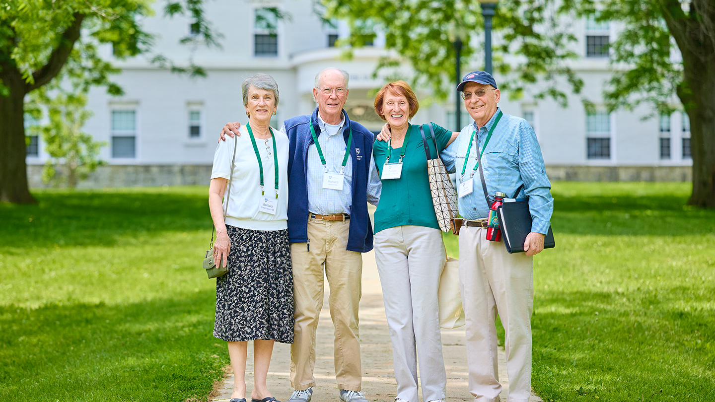 Four Middlebury Reunion attendees pose for a photo with arms around each other.