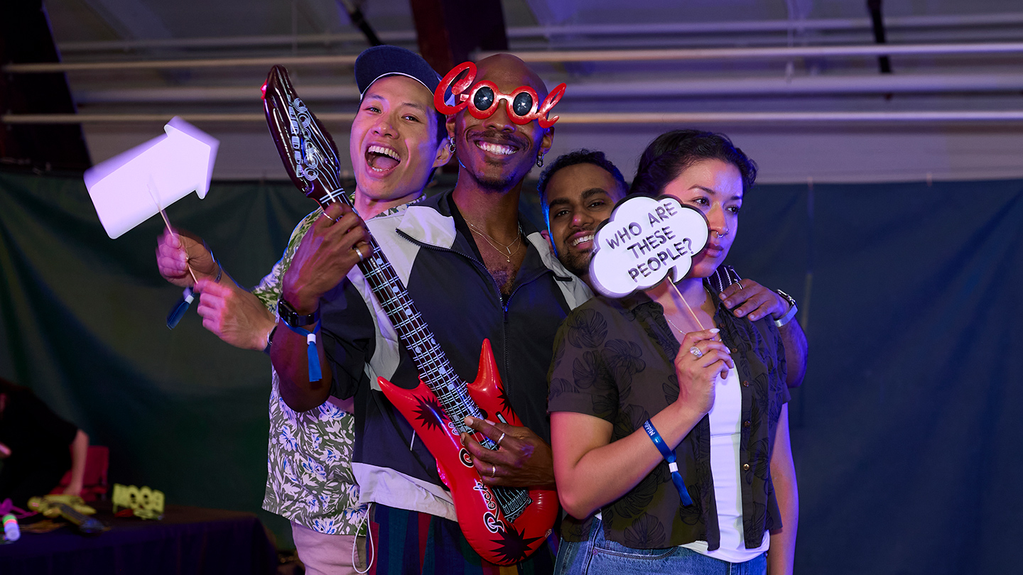 Middlebury alumni pose for a photo with funny props and signs.