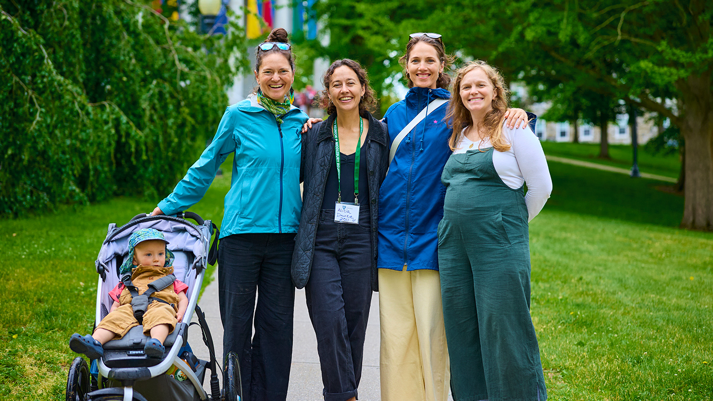 Four Middlebury alumni pose for a photo on campus.