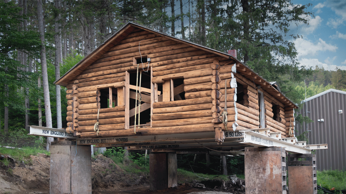 The historic Hubbard log cabin at the Middlebury College Snowbowl jacked up on supports in preparation for moving.