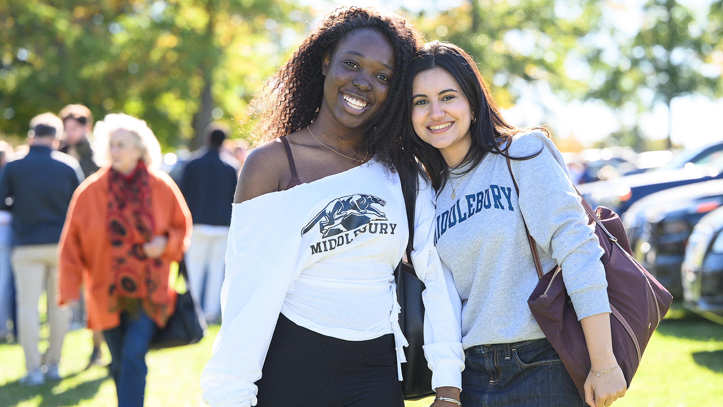 Two students smile and pose for a photo