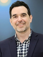 head shot of man with checked shirt and dark blue blazer