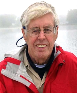 Photo of man in red jacket outdoors.