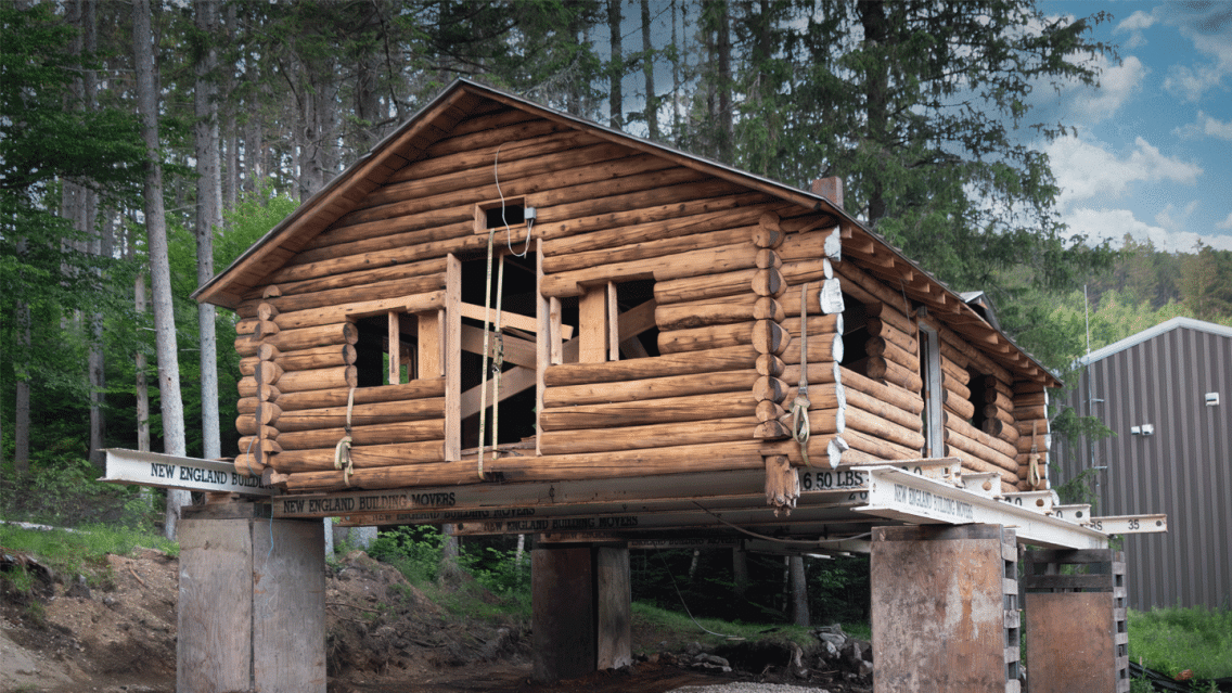 The historic Hubbard log cabin at the Middlebury College Snowbowl jacked up on supports in preparation for moving.