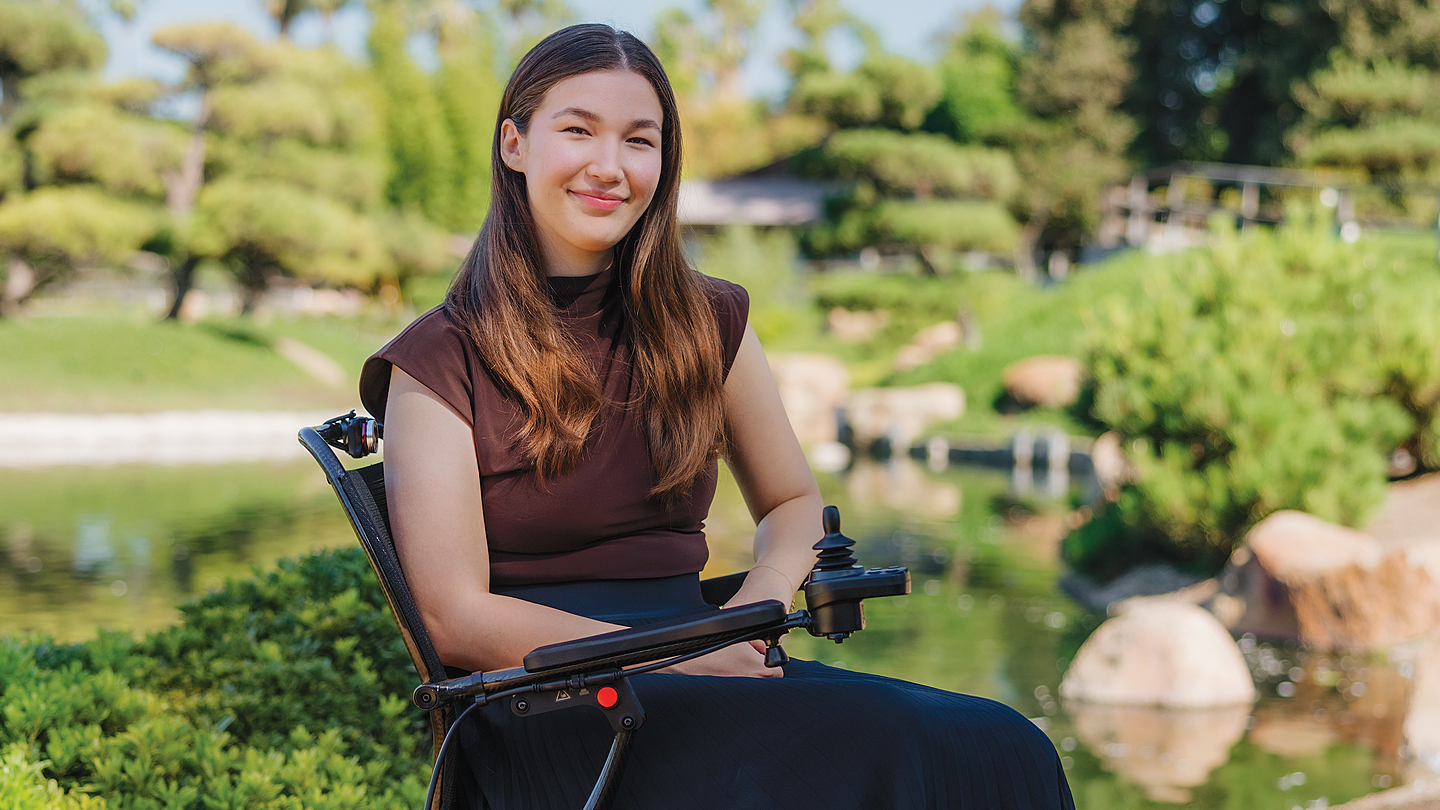 Aubriana Wilson sitting in her wheelchair in a garden