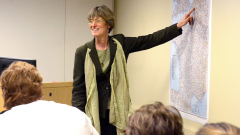 Allison Stanger pointing at a map while giving a presentation 