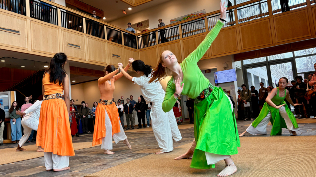 Student dancers in bright colors perform during the annual Spring Symposium.
