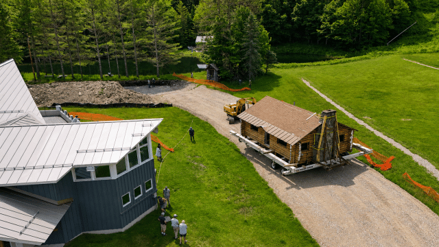 An ariel view of the historic Hubbard log cabin at the Middlebury College Snowbowl being moved to its new location near Starr Lodge.