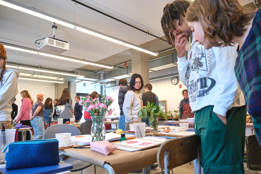 Students in an illustration class review each other's work.